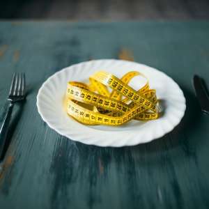 Plate with measuring tape closeup, fat burning